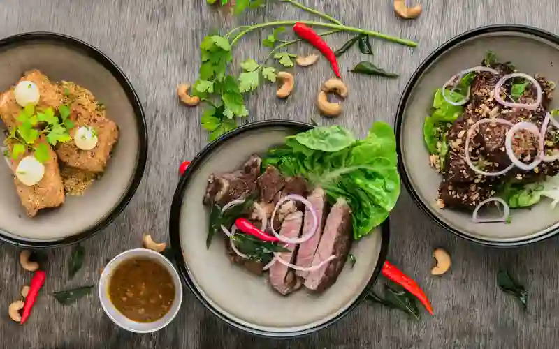 Assorted gourmet dishes served at a San Francisco Bay Area restaurant, featuring sliced steak, fresh herbs, and chef-crafted plates.